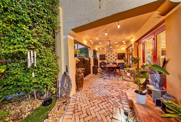 Covered patio featuring herringbone-patterned brick flooring, recessed lighting, and dual-pane glass entry doors