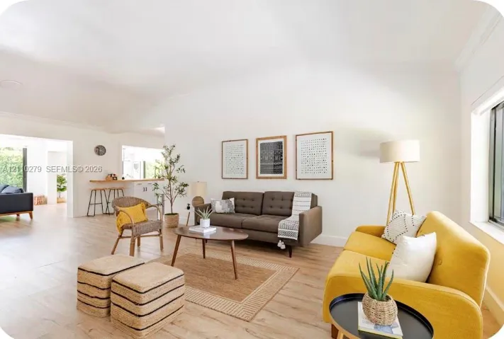 Open-concept interior featuring high vaulted ceilings, wood-finish flooring, and crown molding