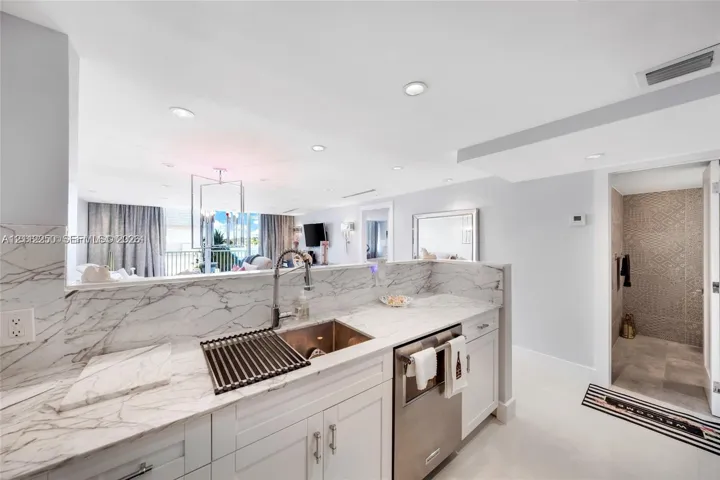 Kitchen featuring stone-patterned countertops, white cabinetry, a stainless steel undermount sink with a gooseneck faucet, and recessed lighting