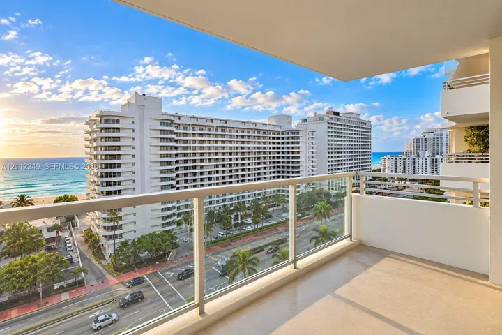 Covered balcony featuring a glass-panel railing and concrete flooring