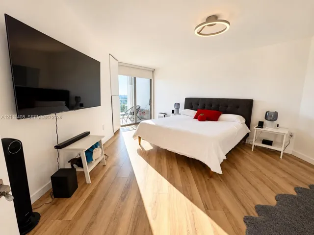 Wood-finish flooring, sliding glass door, and circular LED ceiling light fixture