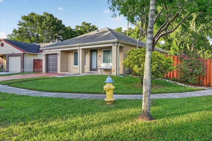 Single-story residence featuring a covered front porch, stucco exterior, hip roof, and an attached garage with a paved driveway