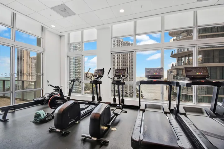 Fitness facility featuring floor-to-ceiling windows, rubberized flooring, and recessed ceiling lighting