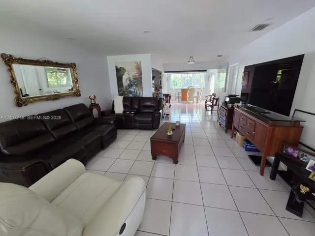 Open-concept interior featuring large-format ceramic tile flooring, recessed lighting, and expansive windows