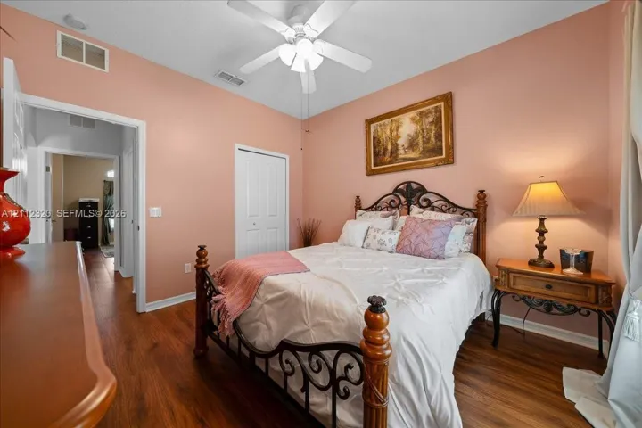 Wood-finish flooring, high ceilings, ceiling fan with integrated lighting, and white six-panel closet door