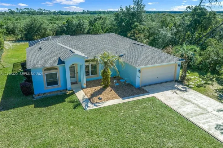 Single-story residence featuring a shingle roof, concrete driveway, attached two-car garage, and landscaped front garden bed with stone mulch