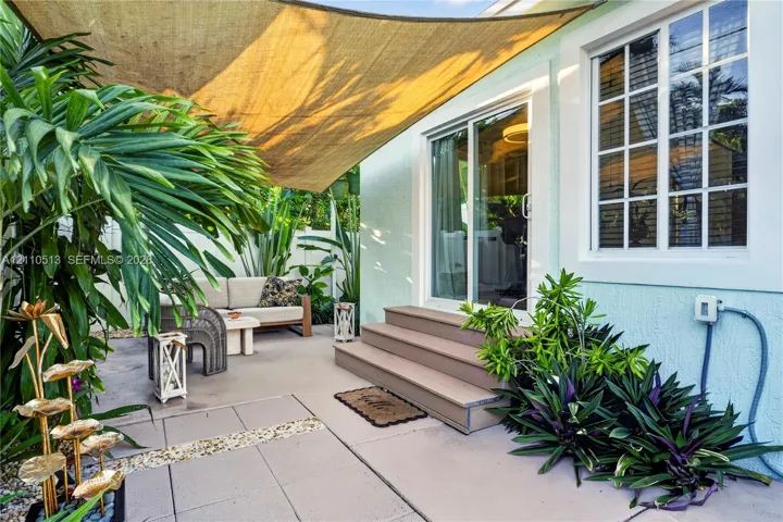 Patio space featuring concrete pavers, multi-pane window, sliding glass door, and stepped exterior platform