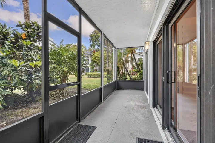 Screen-enclosed porch featuring concrete flooring, aluminum framing, and multi-panel sliding glass doors