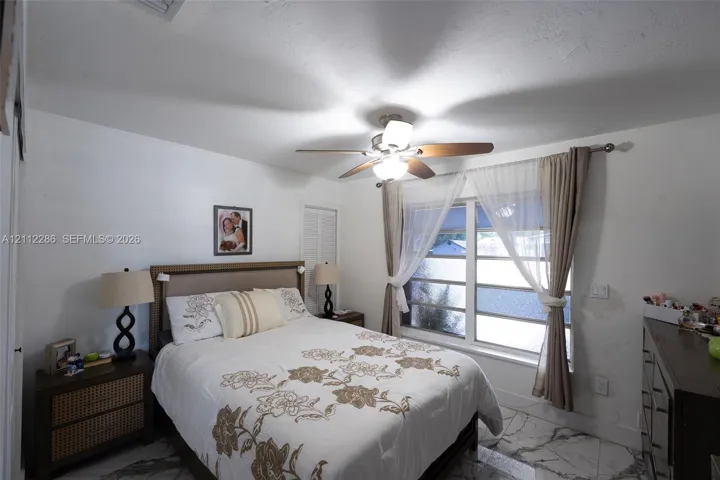Large-format tile flooring, multi-pane window, and integrated ceiling fan with light fixture