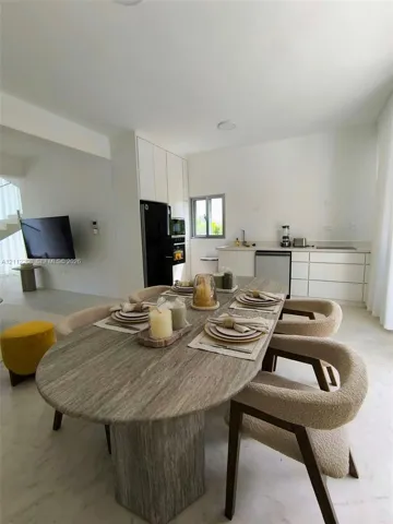 Kitchen featuring flat-panel cabinetry, light-toned stone surfaces, and light-toned stone flooring