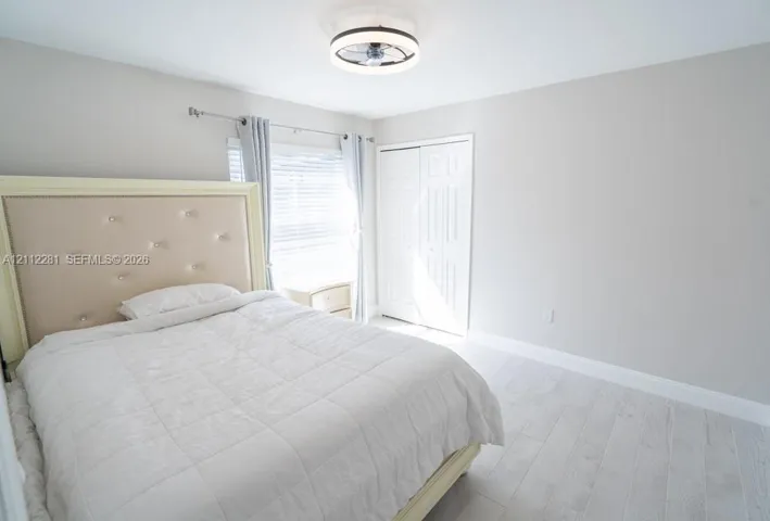 Neutral wall tones, wood-finish flooring, double-panel closet doors, and a low-profile integrated ceiling light fixture