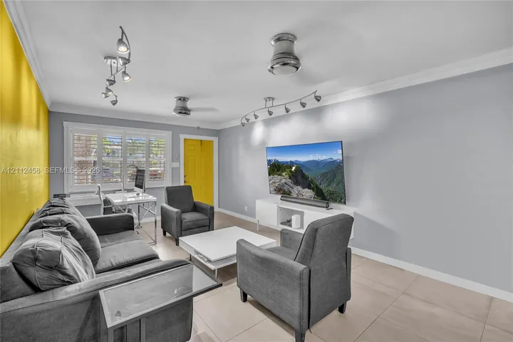 Large-format tile flooring, multi-directional track lighting, ceiling fans, and interior window shutters