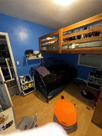Room featuring wood-finish flooring and a built-in wall shelf