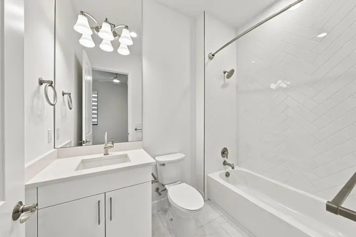 2nd bathroom with upgraded countertop, cabinets, tub/shower with tile and mirror to the ceiling