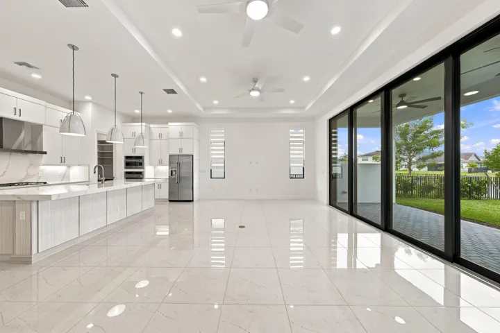 Great room with tray ceilings and upgraded 10ft high x 16ft long sliding glass doors, ceiling fans, island pendant lights