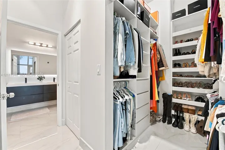 Custom walk-in closet featuring extensive built-in shelving, drawers, and hanging rods