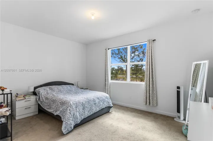 Neutral-toned interior space featuring neutral wall paint, wall-to-wall carpeting, and a multi-pane window
