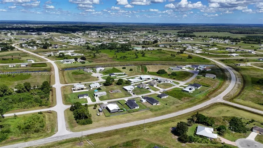 Aerial perspective of a planned subdivision featuring paved roadway infrastructure, concrete cul-de-sacs, and established residential lots with expansive green space