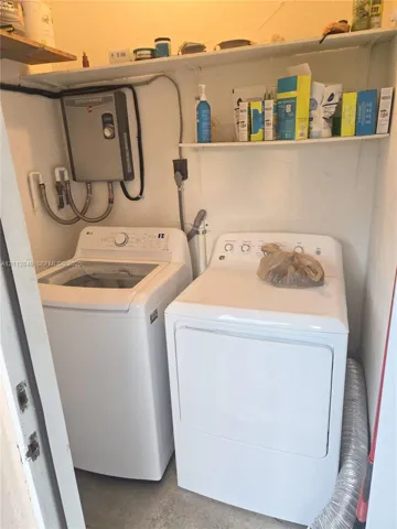 Laundry area featuring wall-mounted shelving and a tankless water heater