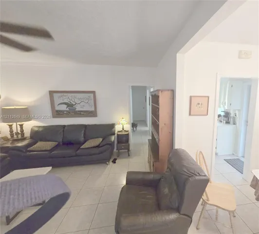 Light-toned ceramic tile flooring, ceiling fan with integrated lighting, and neutral wall finishes