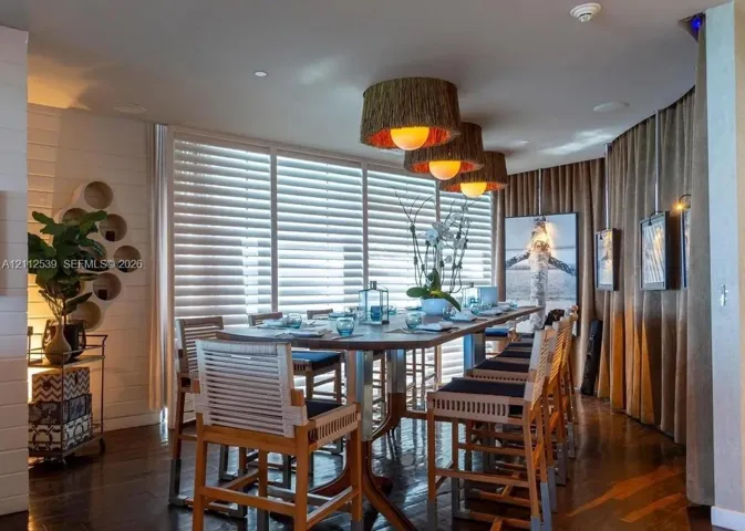 Wall-mounted circular shelving unit, wood-finish flooring, floor-to-ceiling windows with integrated horizontal blinds, and trio of textured drum pendant lights