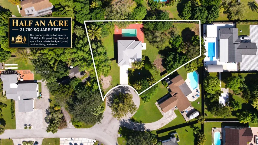 Half-acre lot featuring a swimming pool, expansive grounds, mature trees, and a concrete driveway