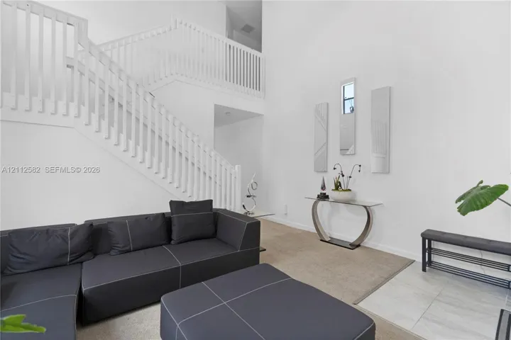 Two-story foyer featuring high ceilings, open-railing staircase, and polished tile flooring