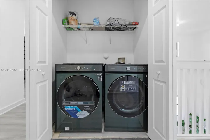Laundry closet featuring double-panel doors, overhead wire shelving, and dedicated washer and dryer hookups