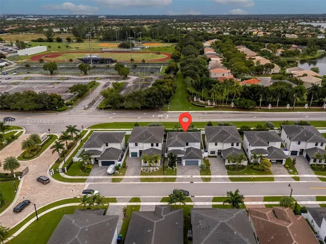 Aerial perspective of a two-story residence featuring a multi-pitched roof, attached garage, paved driveway, and established community​​‌​​​​‌​​‌‌​‌‌​​​‌‌​‌​‌​‌​​​‌​​ landscaping