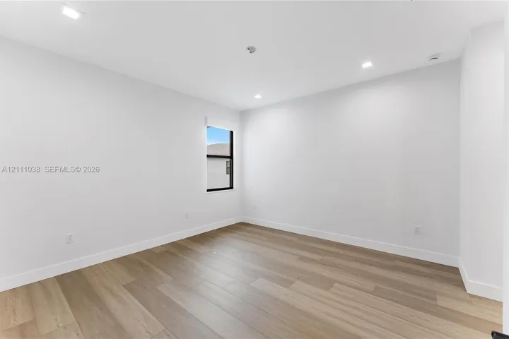 Interior space featuring wood-finish flooring, recessed lighting, and a window with a dark frame