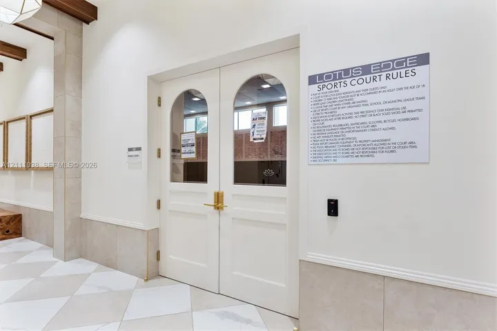 Double doors featuring arched glass panels, brass hardware, and electronic keyless entry