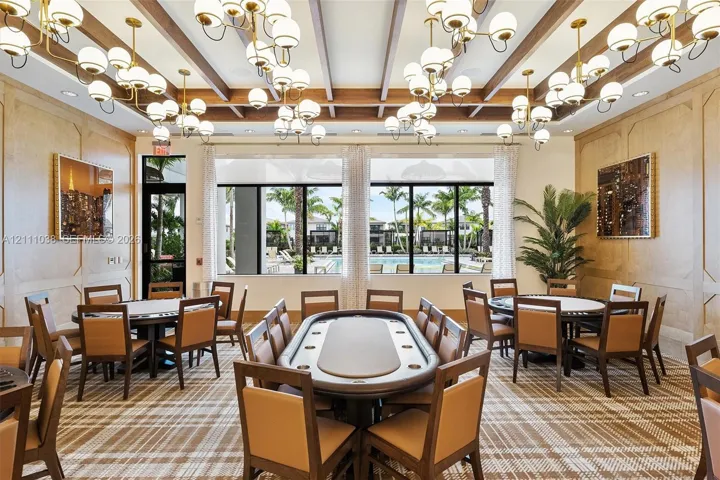 Wood-paneled wall treatments, coffered ceiling with exposed beams, and multiple oversized multi-globe chandeliers