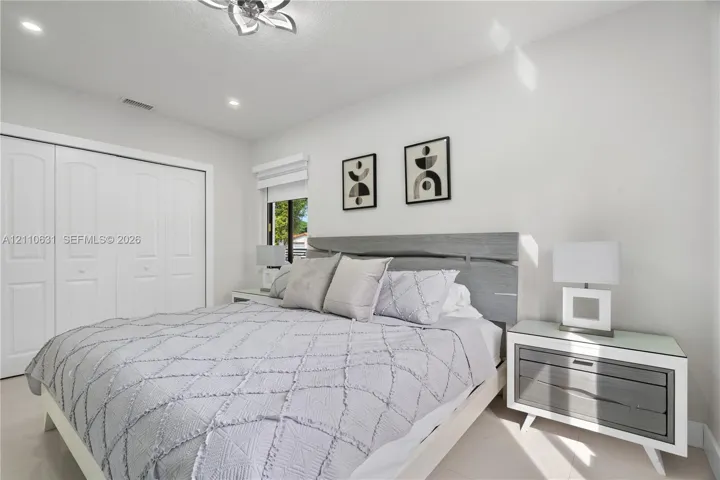 Bright room featuring recessed lighting, a decorative ceiling fixture, porcelain tile flooring, and sliding closet doors