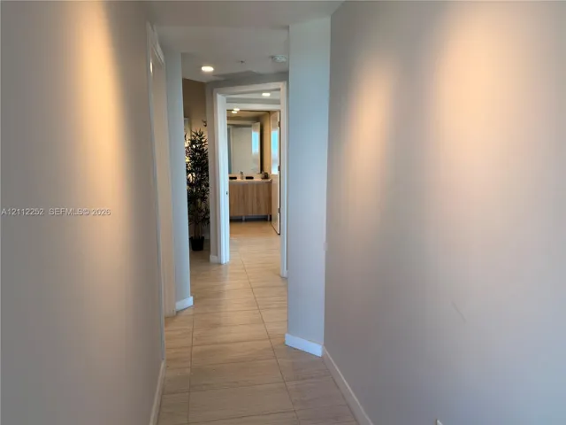 Hallway featuring neutral-toned wall paint, large-format tile flooring, and recessed ceiling lighting