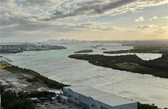 Panoramic bay and coastal skyline scenery featuring expansive water frontage, mangrove-lined shorelines, and distant urban horizon