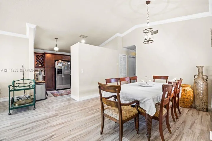 Vaulted ceilings, wood-finish flooring, custom built-in wine storage, and decorative pendant lighting