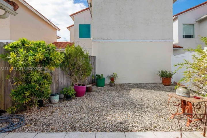 Enclosed patio area featuring crushed stone ground cover and perimeter wood fencing