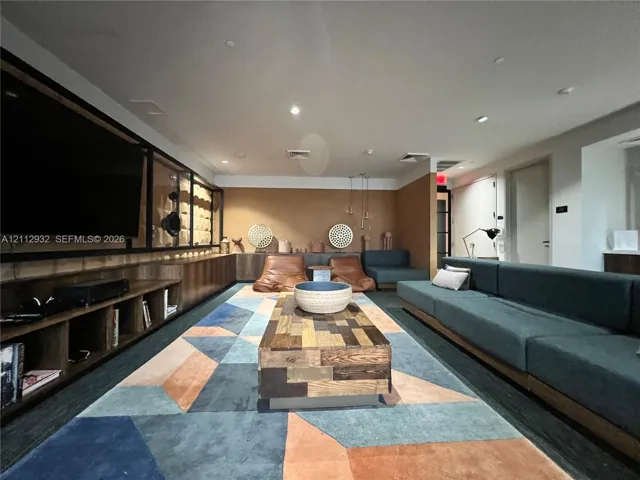 Custom wood cabinetry featuring integrated open shelving, recessed ceiling lighting, and solid surface paneling