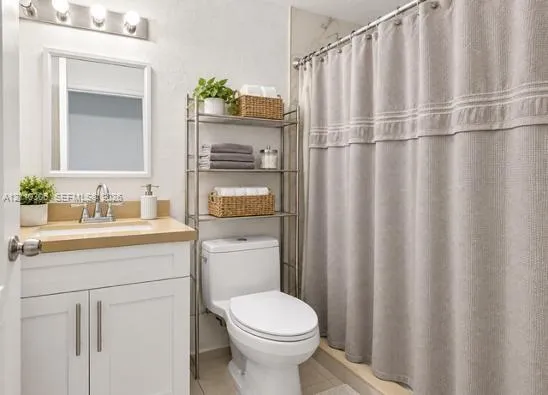 Bathroom featuring a white vanity cabinet, solid-surface countertop with an integrated sink, polished chrome faucet, framed wall mirror, and vanity lighting fixture