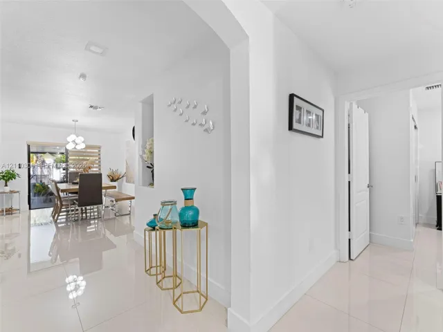 Polished tile flooring, recessed lighting, arched wall opening, and a built-in recessed display niche