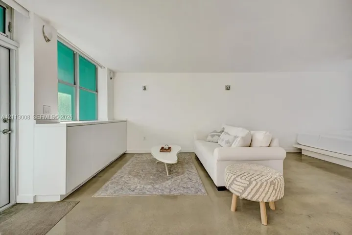 Polished concrete flooring, built-in floor-to-ceiling cabinetry, and wall-mounted light fixtures