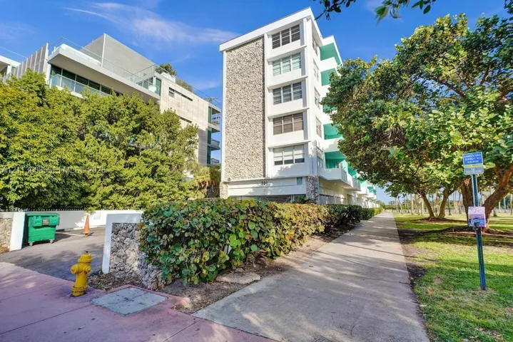 Mid-century modern residential building featuring a stone-clad facade, private balconies, and concrete construction