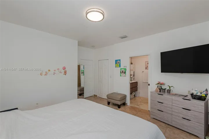 Neutral interior featuring tile flooring, six-panel interior doors, and a flush-mount circular ceiling light fixture