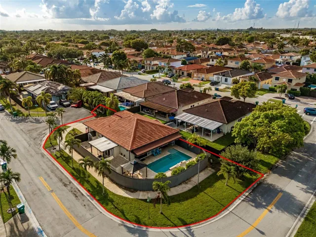 Corner lot featuring a tiled roof, fenced outdoor area, and a private swimming pool