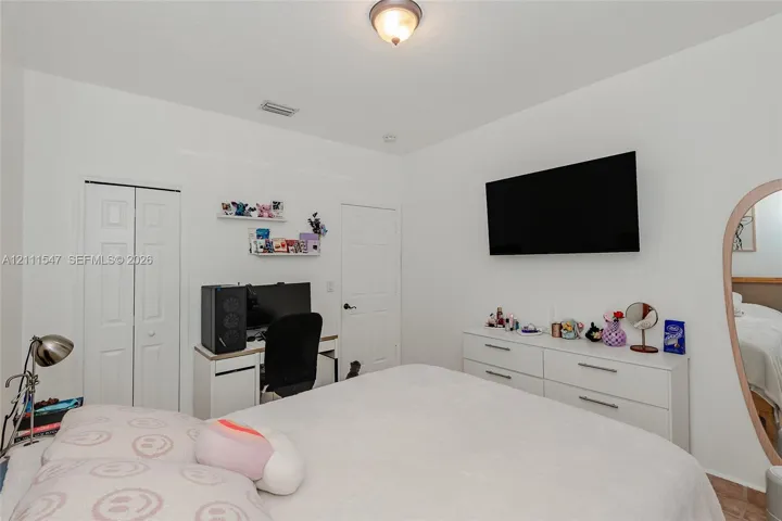 Interior room featuring neutral wall paint, bi-fold closet doors, a traditional interior door, and a flush-mount ceiling light fixture