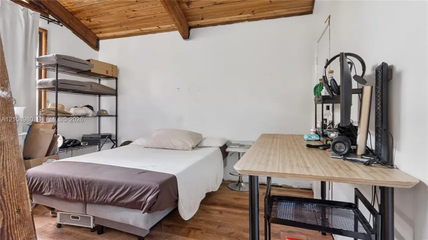 Vaulted ceiling with exposed wood-finish beams and wood-finish flooring