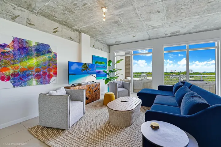 Exposed concrete ceiling, floor-to-ceiling windows, and large-format tile flooring