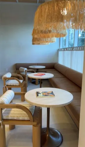 Built-in upholstered banquette seating, floor-to-ceiling windows, and textured fiber pendant lighting