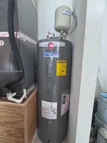 Vertical water heater featuring a thermal expansion tank and metallic plumbing connections