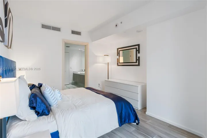 Neutral wall paint, wood-finish flooring, and minimalist architectural trim
